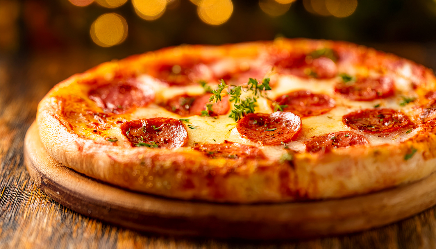 A close-up of a freshly baked pizza with cheese, pepperoni, and